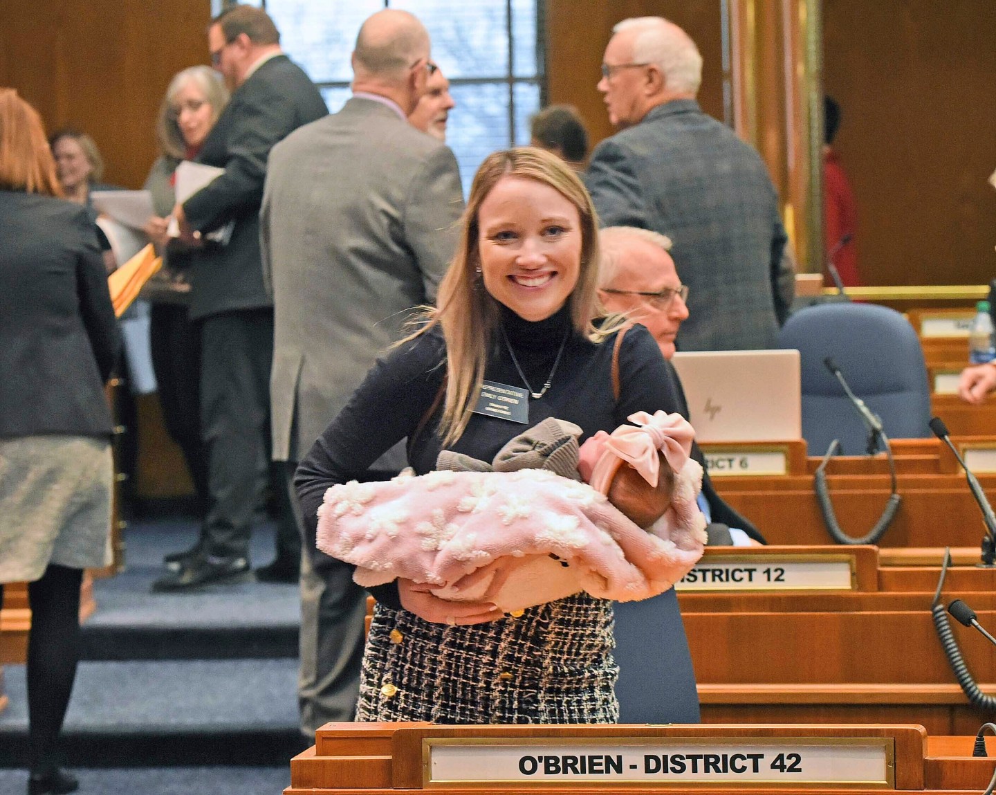 Rep. Emily O'Brien R-Grand Forks carries daughter Jolene Green, 3 weeks, into the House chamber, Dec. 6, 2022, in Bismarck, N.D.