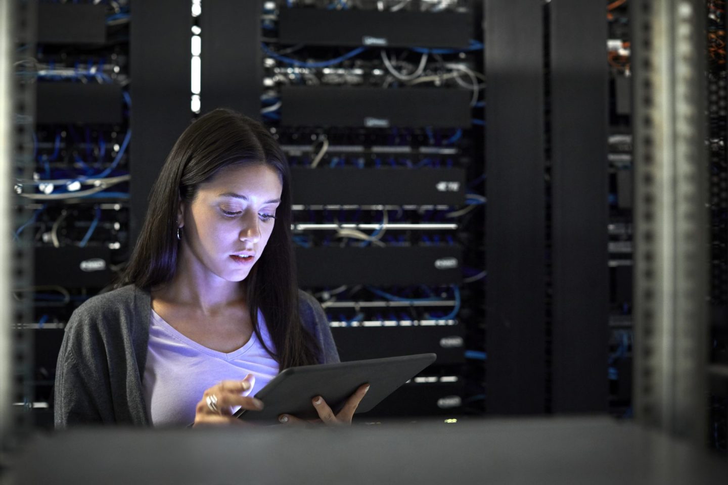 Female engineer using digital tablet in server room