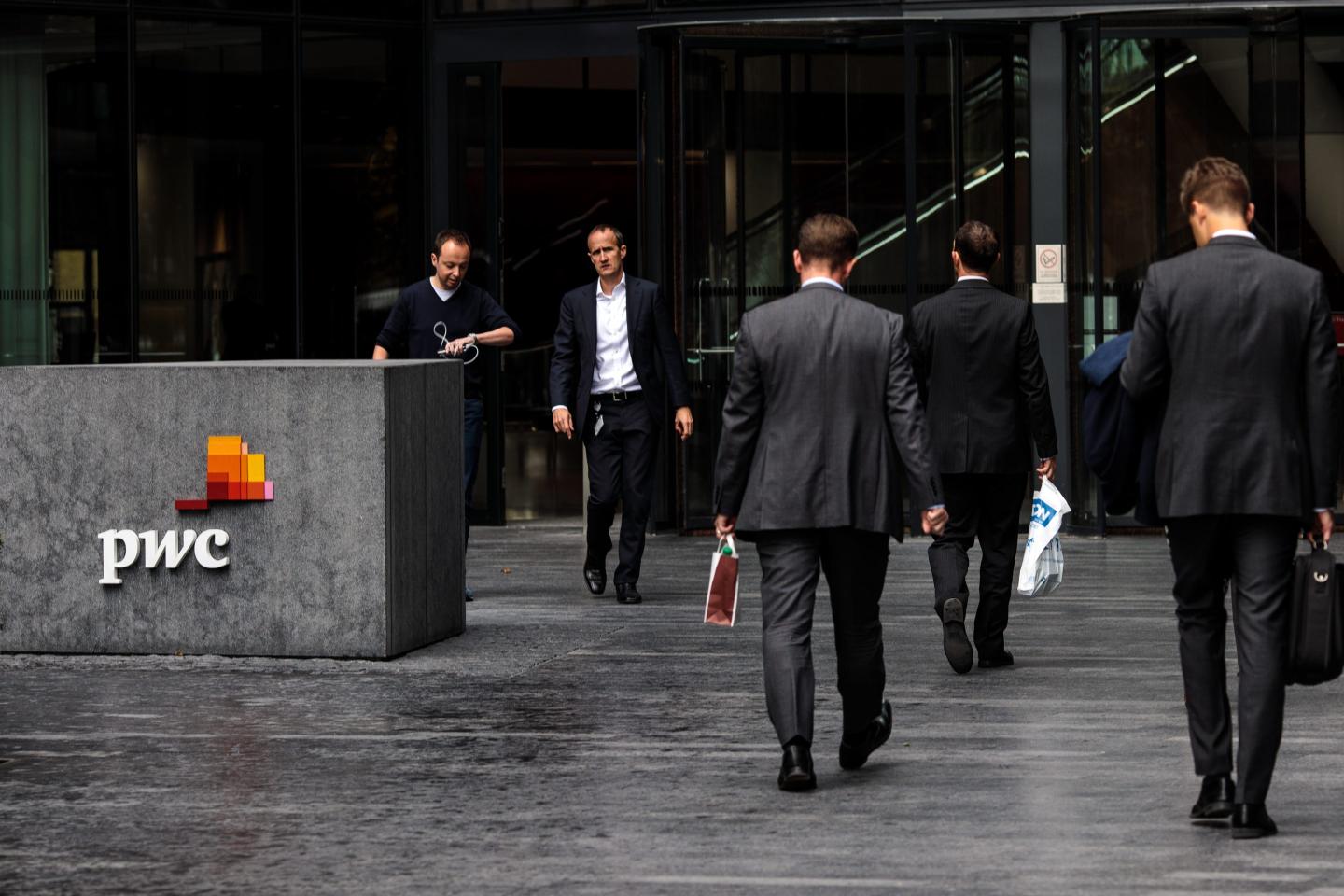 people walking outside a PwC office