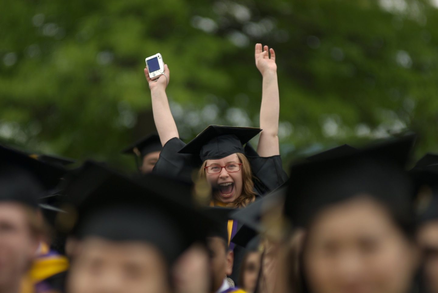 Female college student cheering her graduation.
