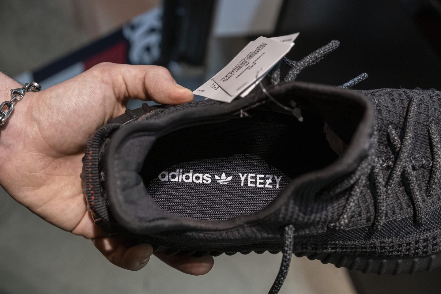 a person holding a black sneaker shoe