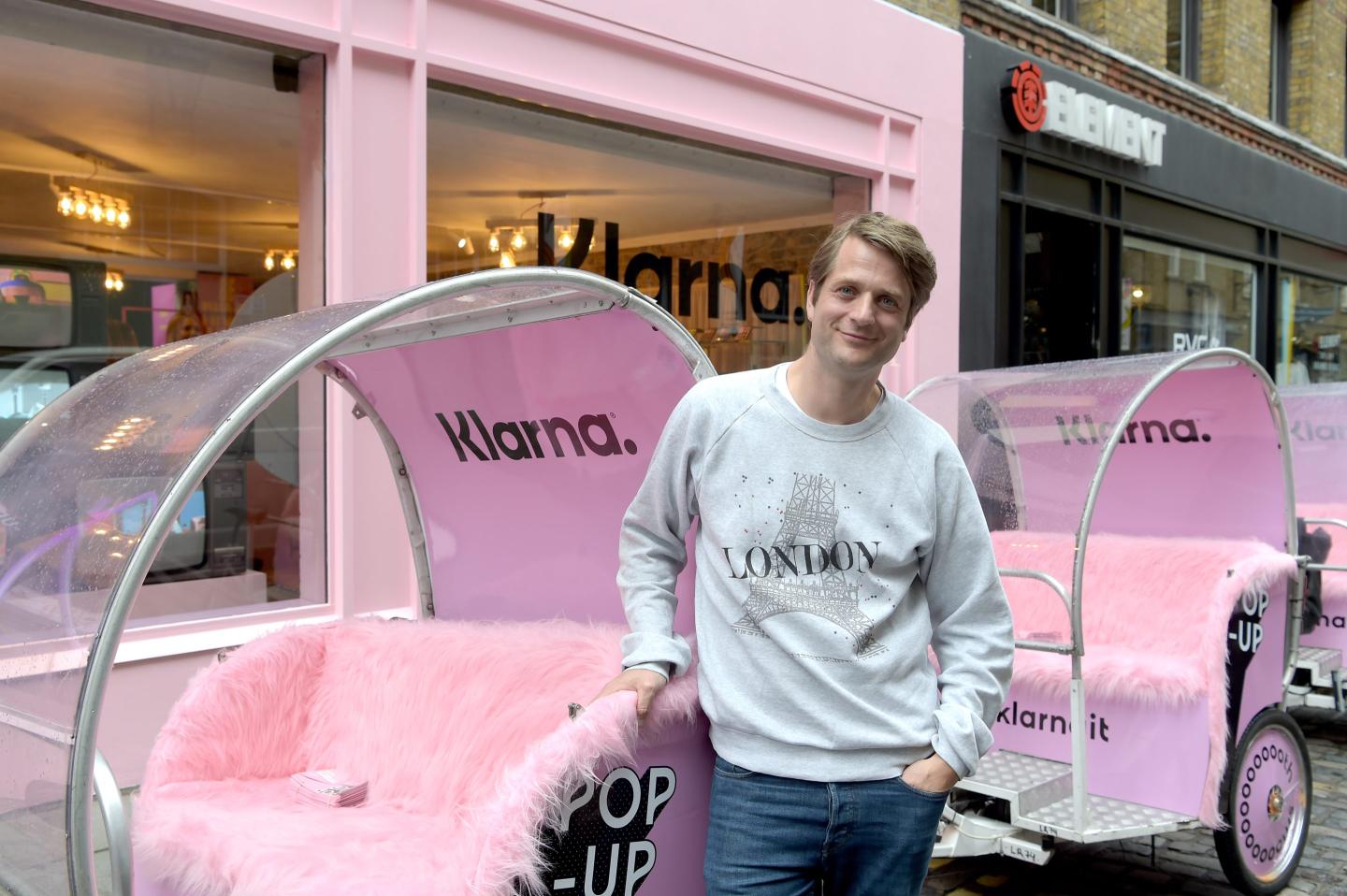 Klarna CEO Sebastian Siemiatkowski stands in front of pink Klarna-branded bikes.