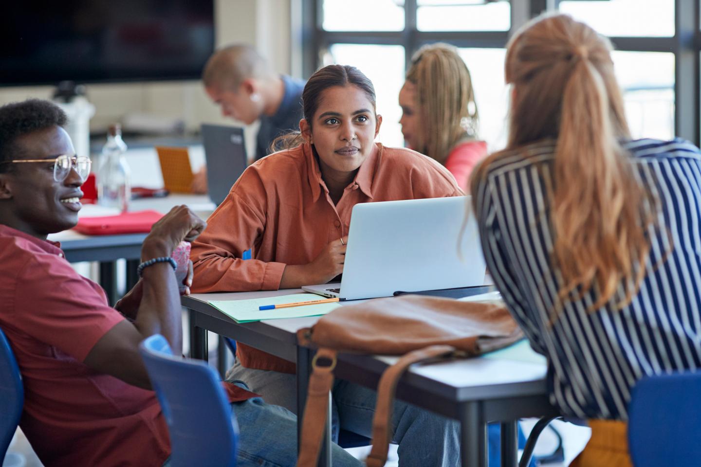 Gen Zers talk among each other in a classroom.
