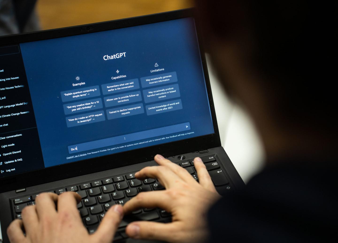 Someone types on a laptop, which displays the generative AI chat bot ChatGPT on the screen.