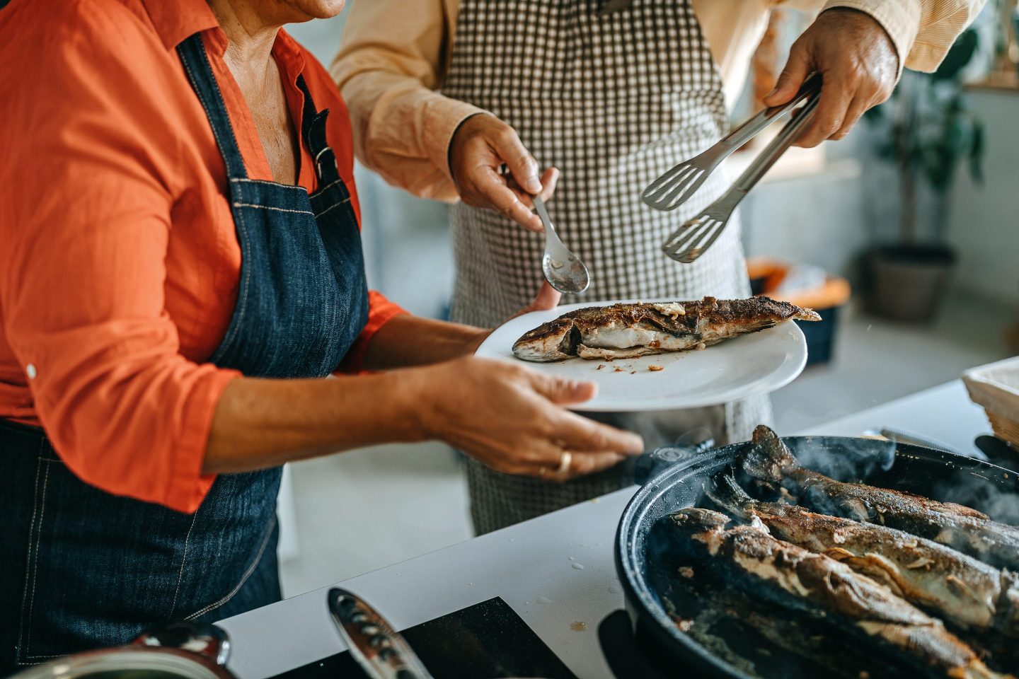 Man and woman cooking fresh fish