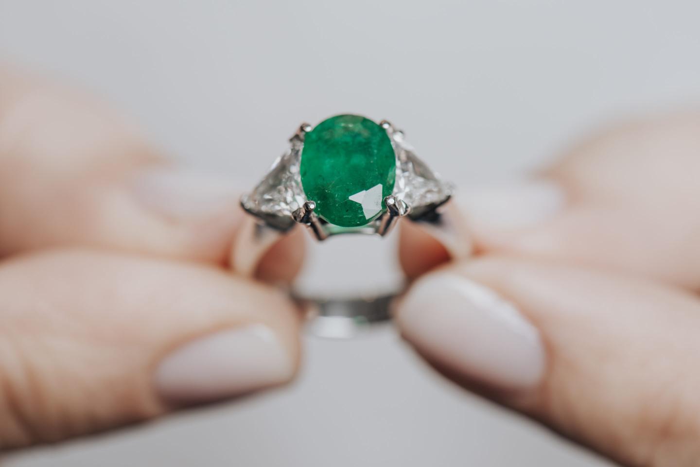 Hands showing diamond. Emerald.