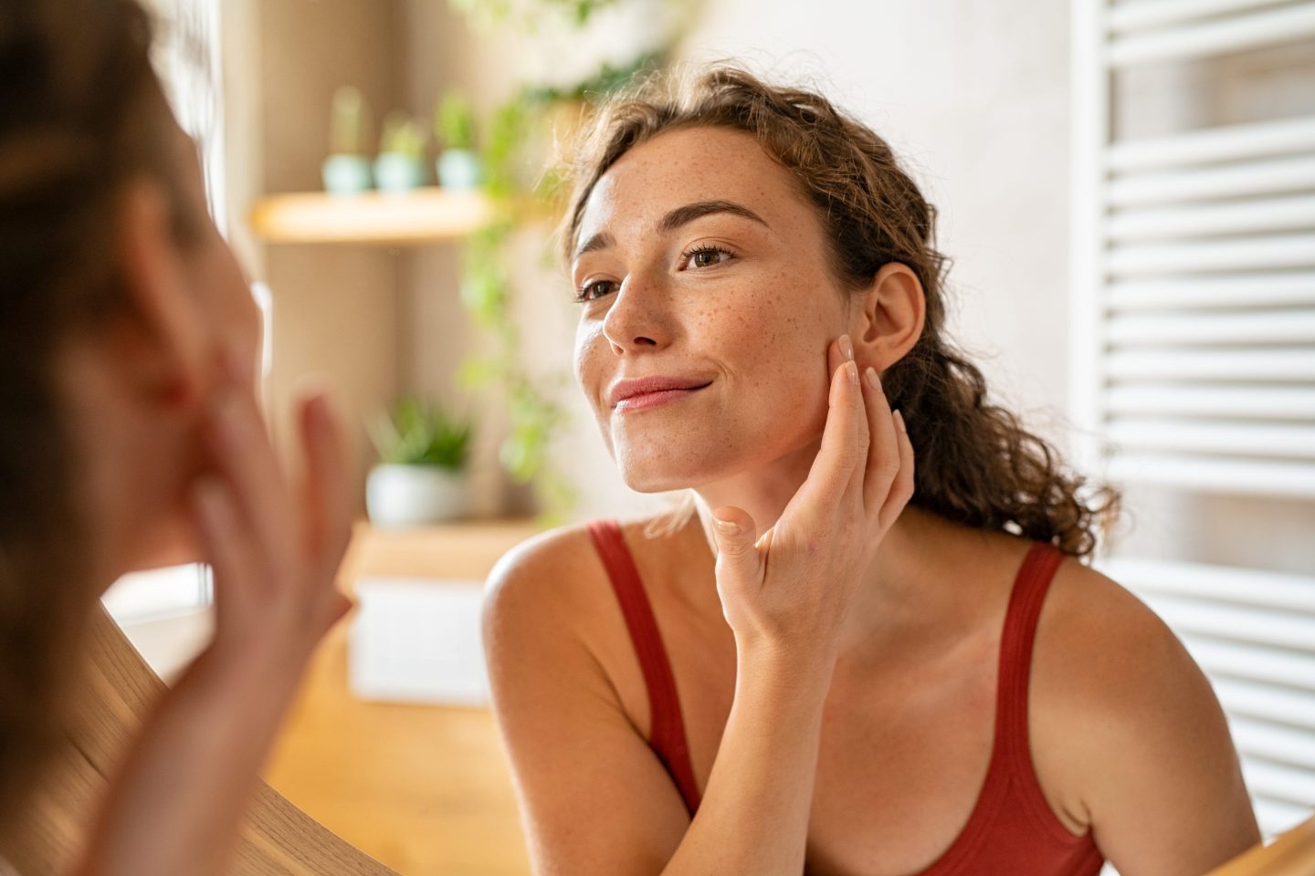 Young woman examining her face in a mirror