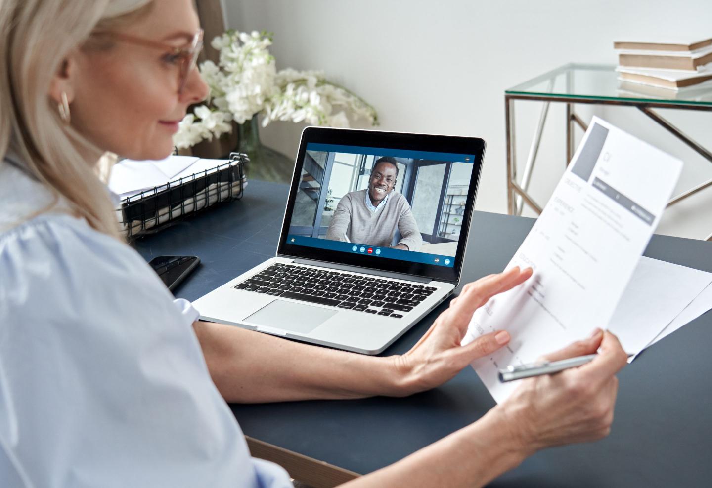 Business woman on a video job interview with a young male candidate