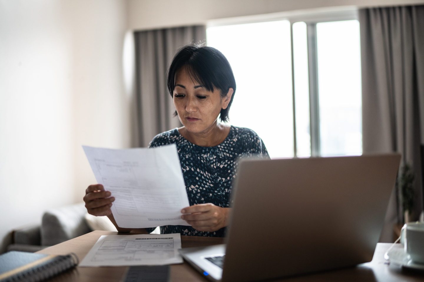 Woman looking concerned as she reviews paperwork