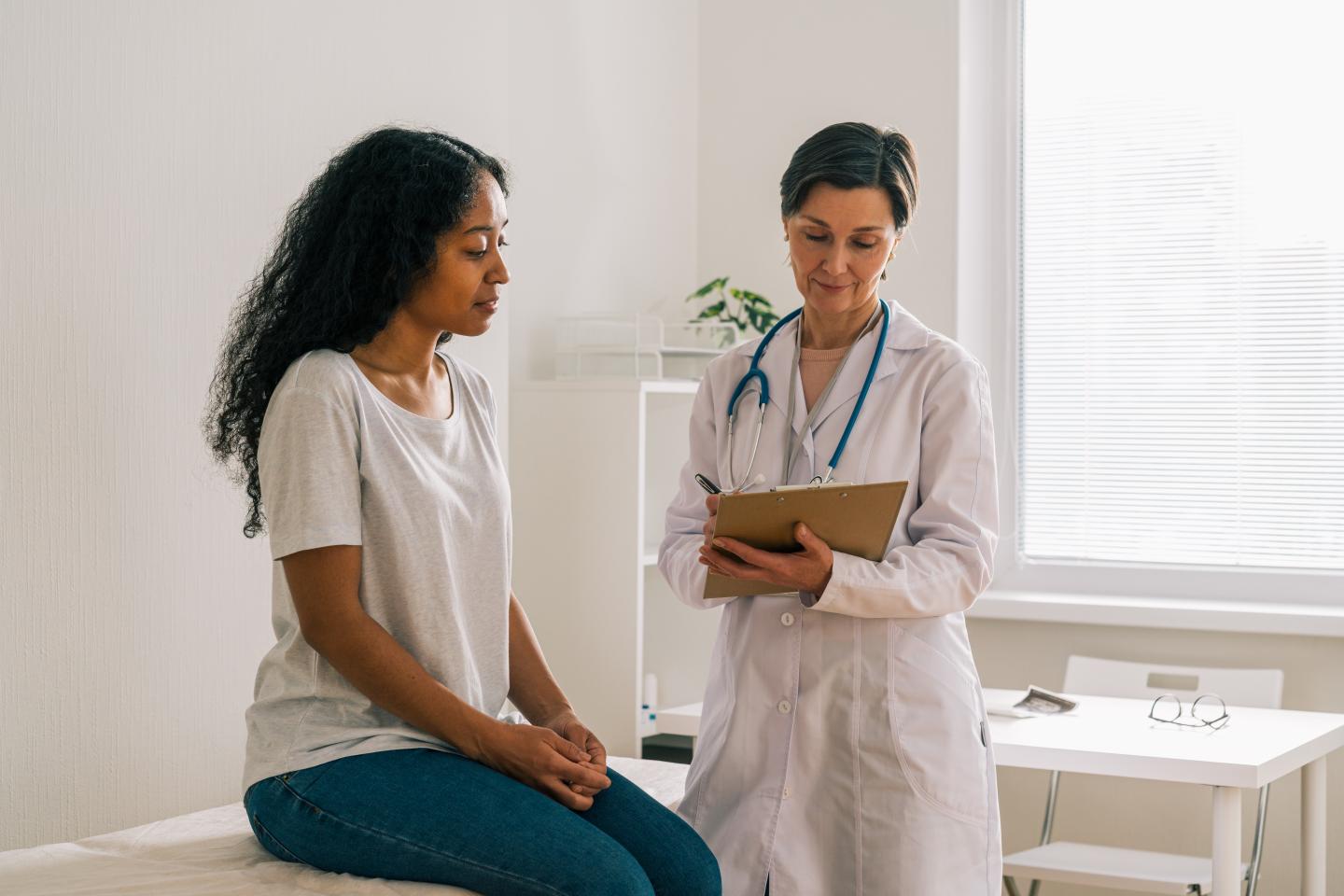 Doctor and patient have a discussion in a hospital room.