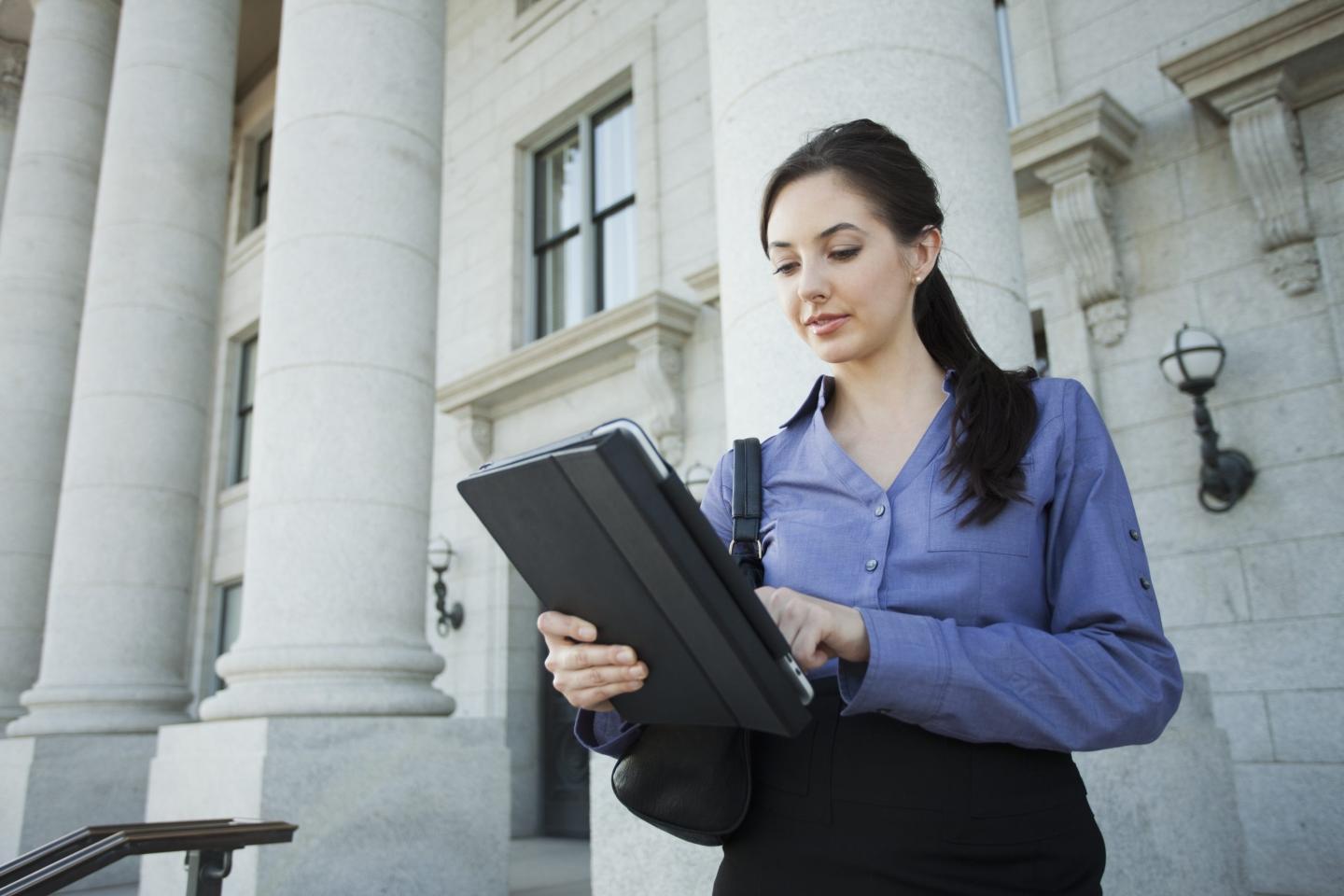 Young businesswoman using a digital tablet outdoors