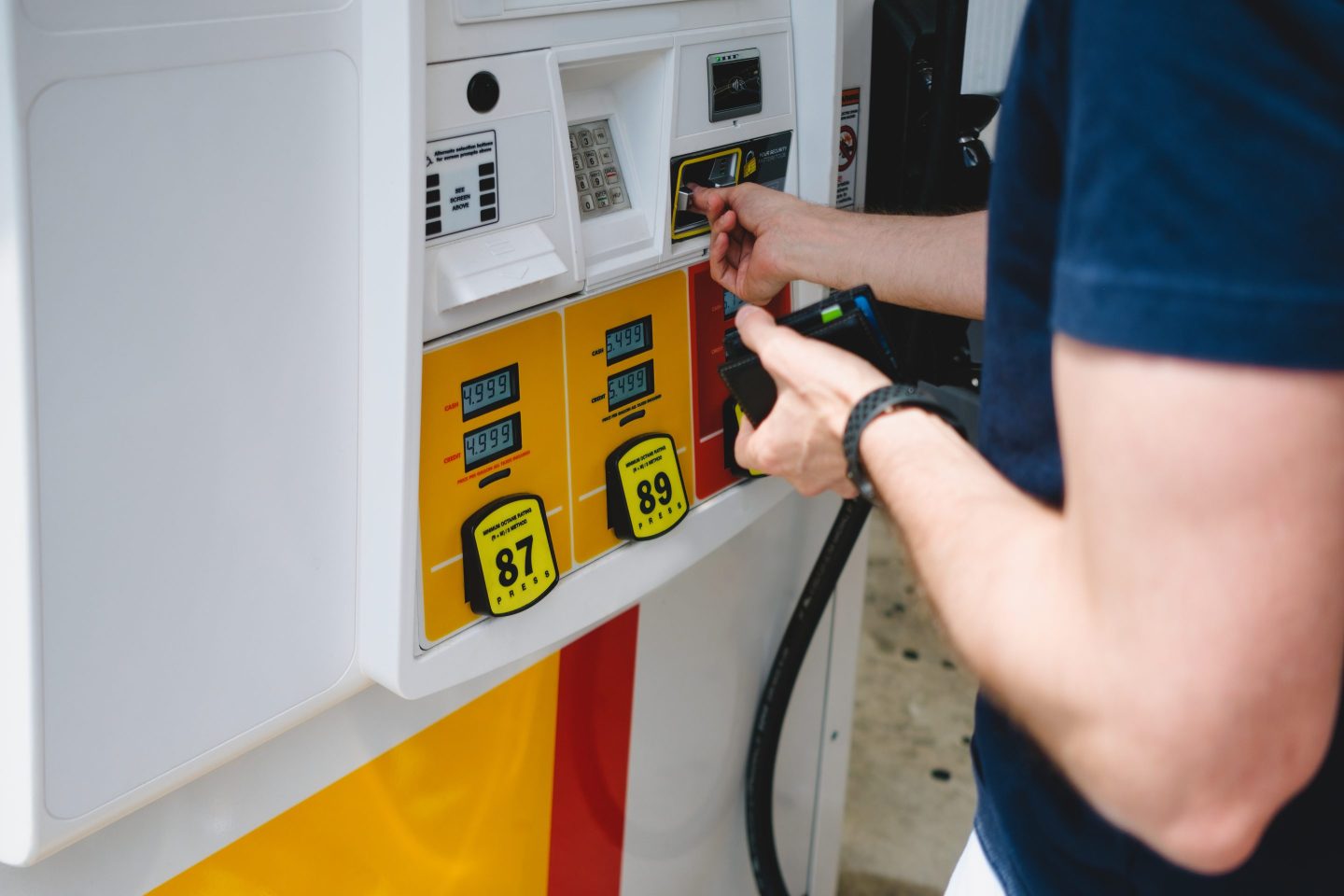 Photo of a person using a credit card at a gas pump