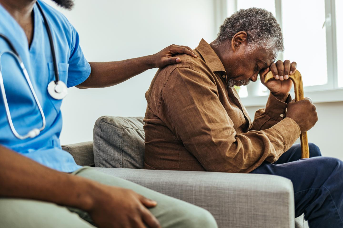Doctor comforts a stressed elder.