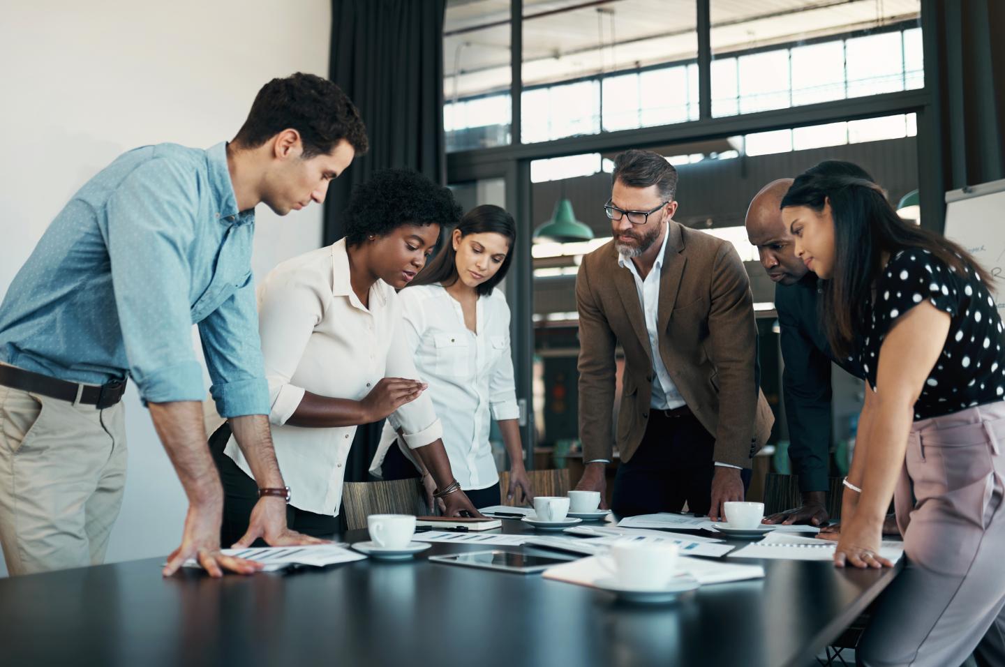 A group of professionals gather in a meeting.