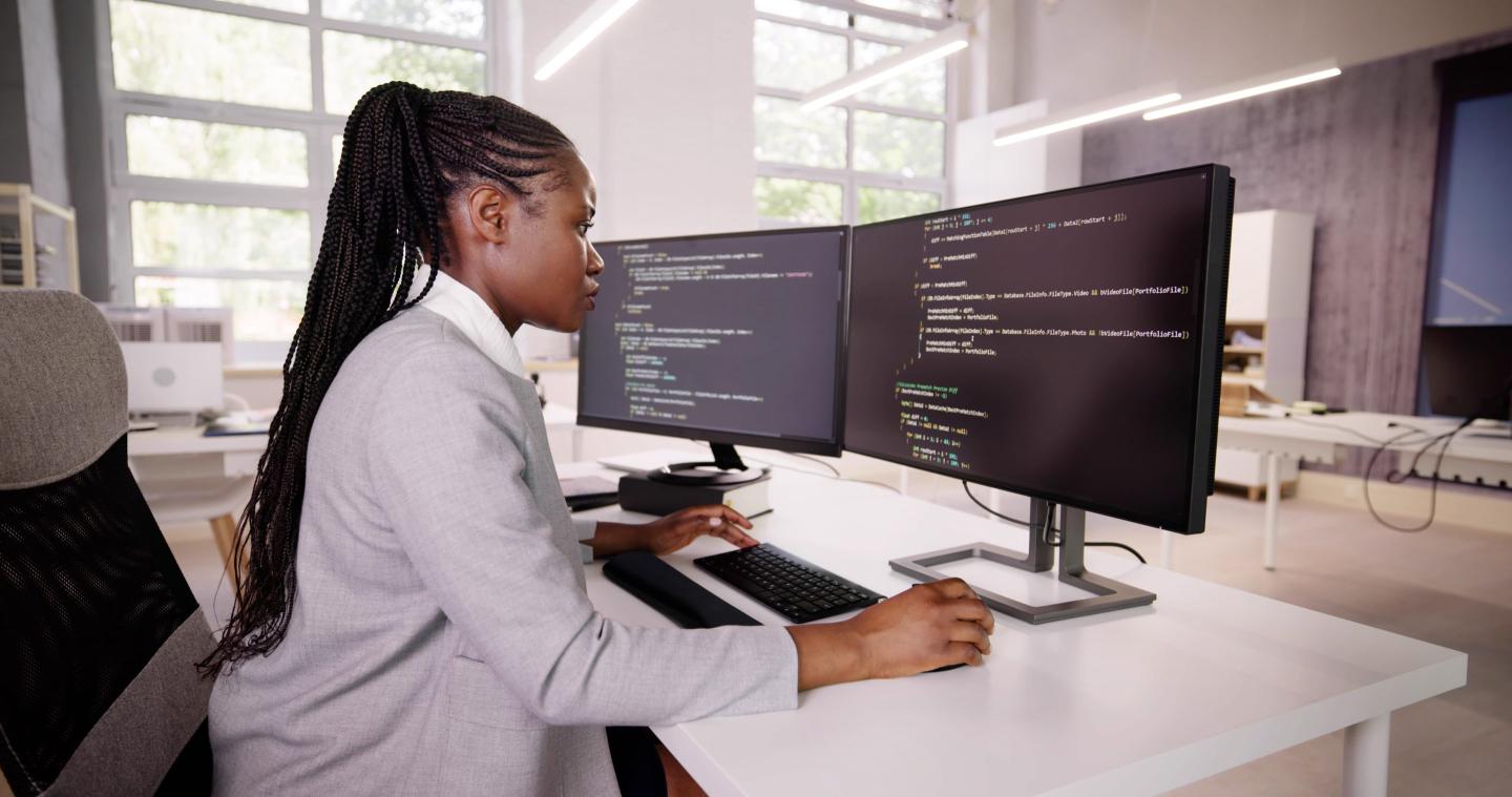 African American Coder Using Computer At Desk