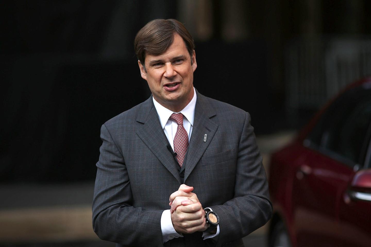 Ford CEO Jim Farley holding his hands together, as if he was praying for people to buy more Mach-E cars