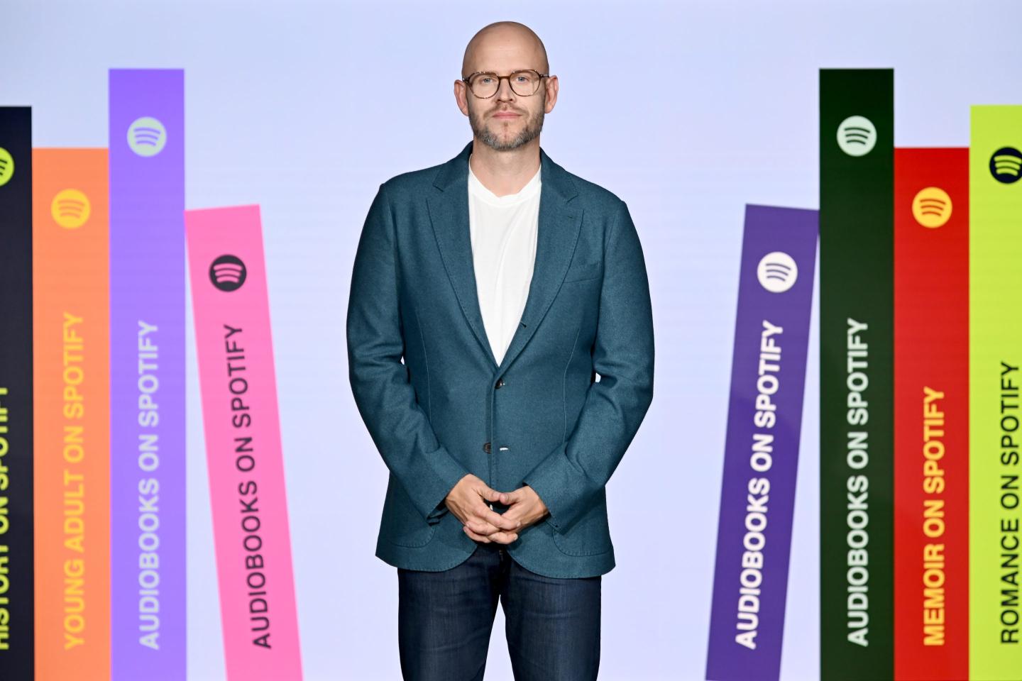 Spotify CEO Daniel Ek posed behind digital books.