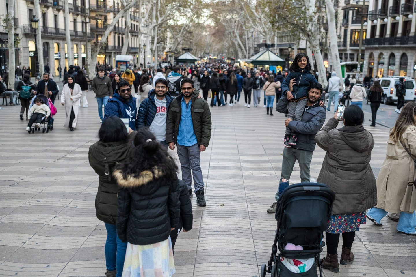 Family of tourists take pictures on Barcelona's Ramblas, one of the most touristed points of the city on Jan. 13, 2024.