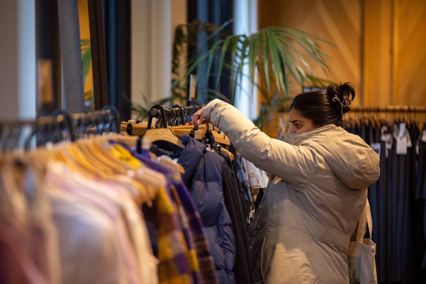 Shopper looking at coat in a store