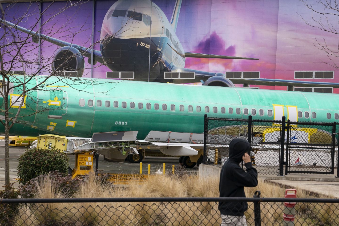 A worker walks near a Boeing 737 fuselage outside the Boeing manufacturing facility in Renton, Wash. on Feb. 5, 2024.