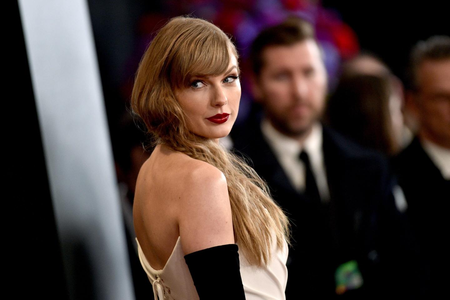 Taylor Swift looks over her shoulder.