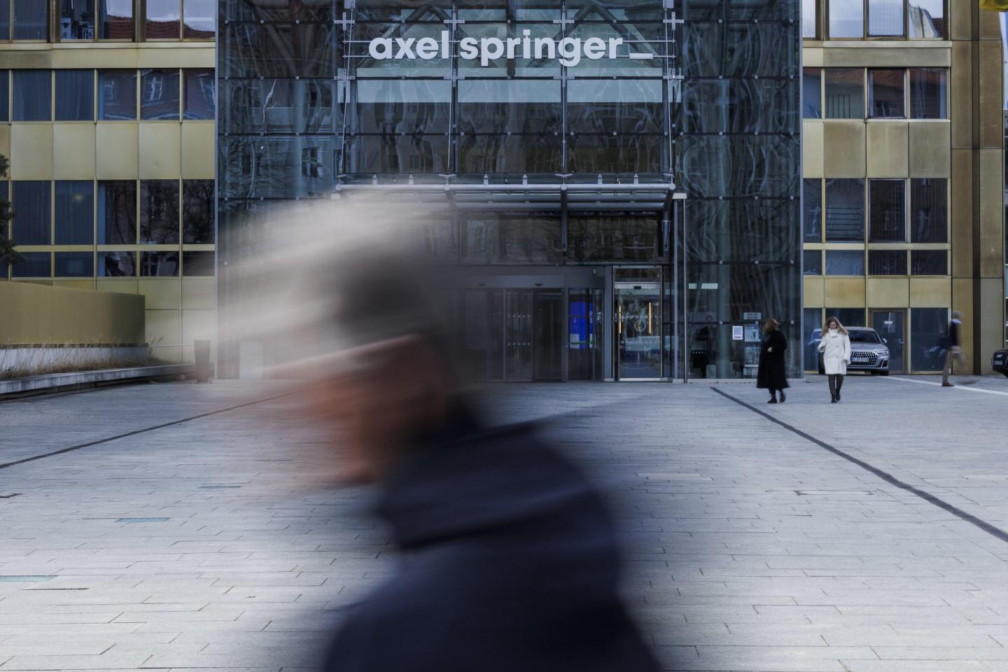 13 February 2024, Berlin: Passers-by walk in front of the main entrance to the Axel Springer high-rise.