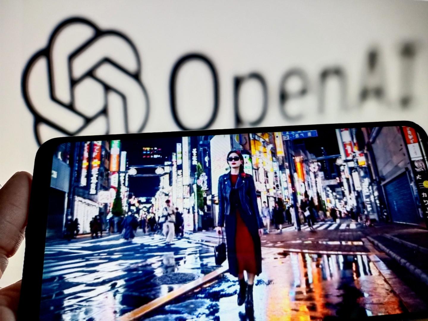 Smartphone showing screen shot from OpenAI's demo video for Sora displayed in front of the OpenAI logo.