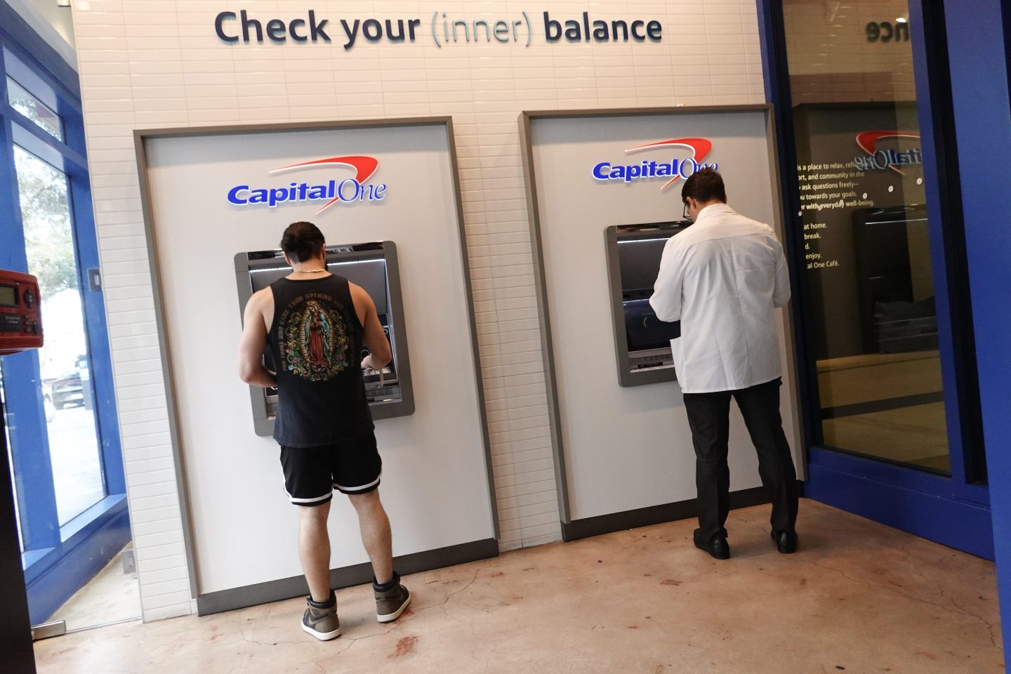 Customers make a transaction at a Capital One ATM