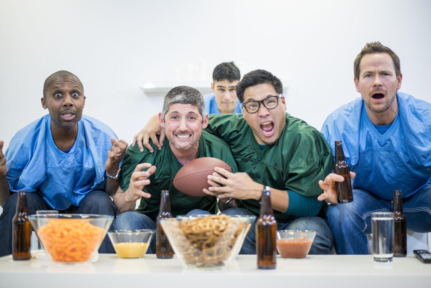 A group of guys watching American Football together and having a party.