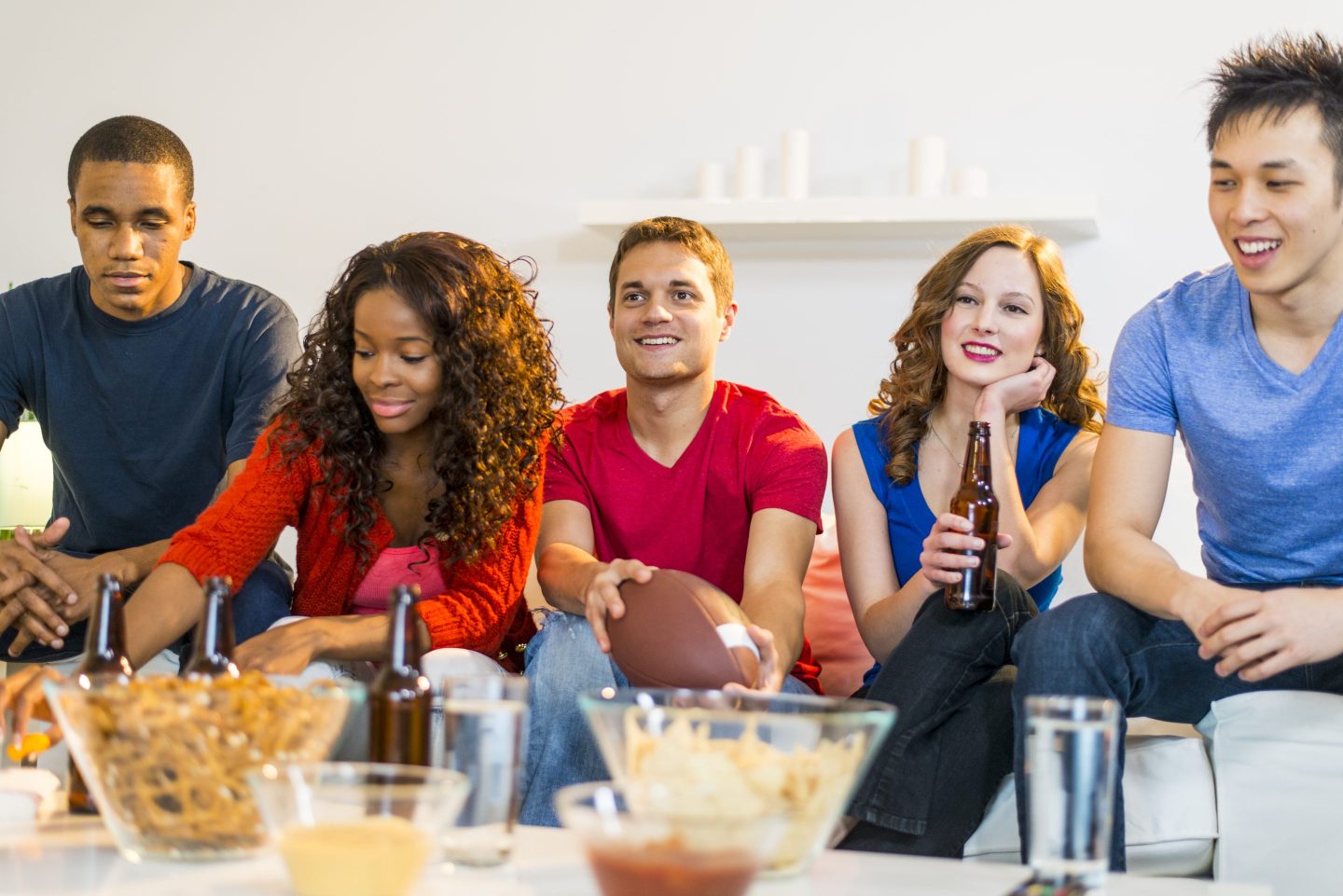 Friends gather around a TV for game-day festivities.