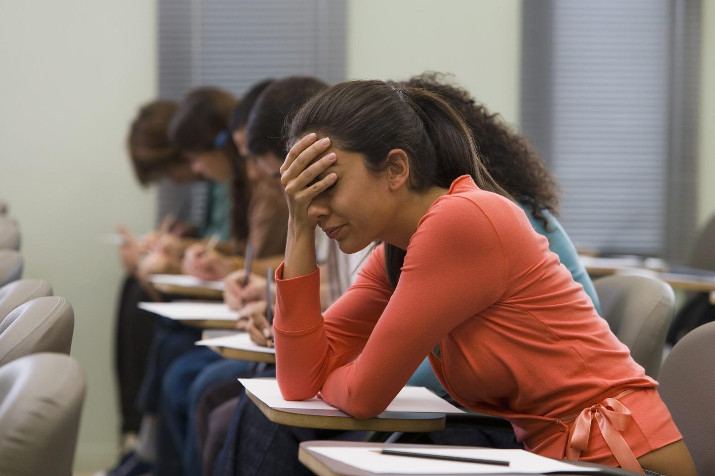 College-aged woman holding her forehead