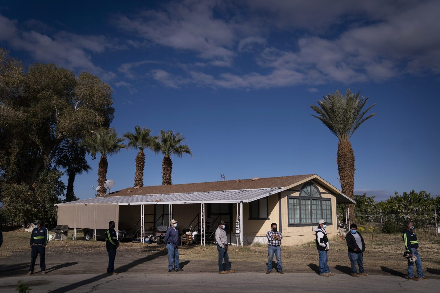 People standing in line outside of shade structure