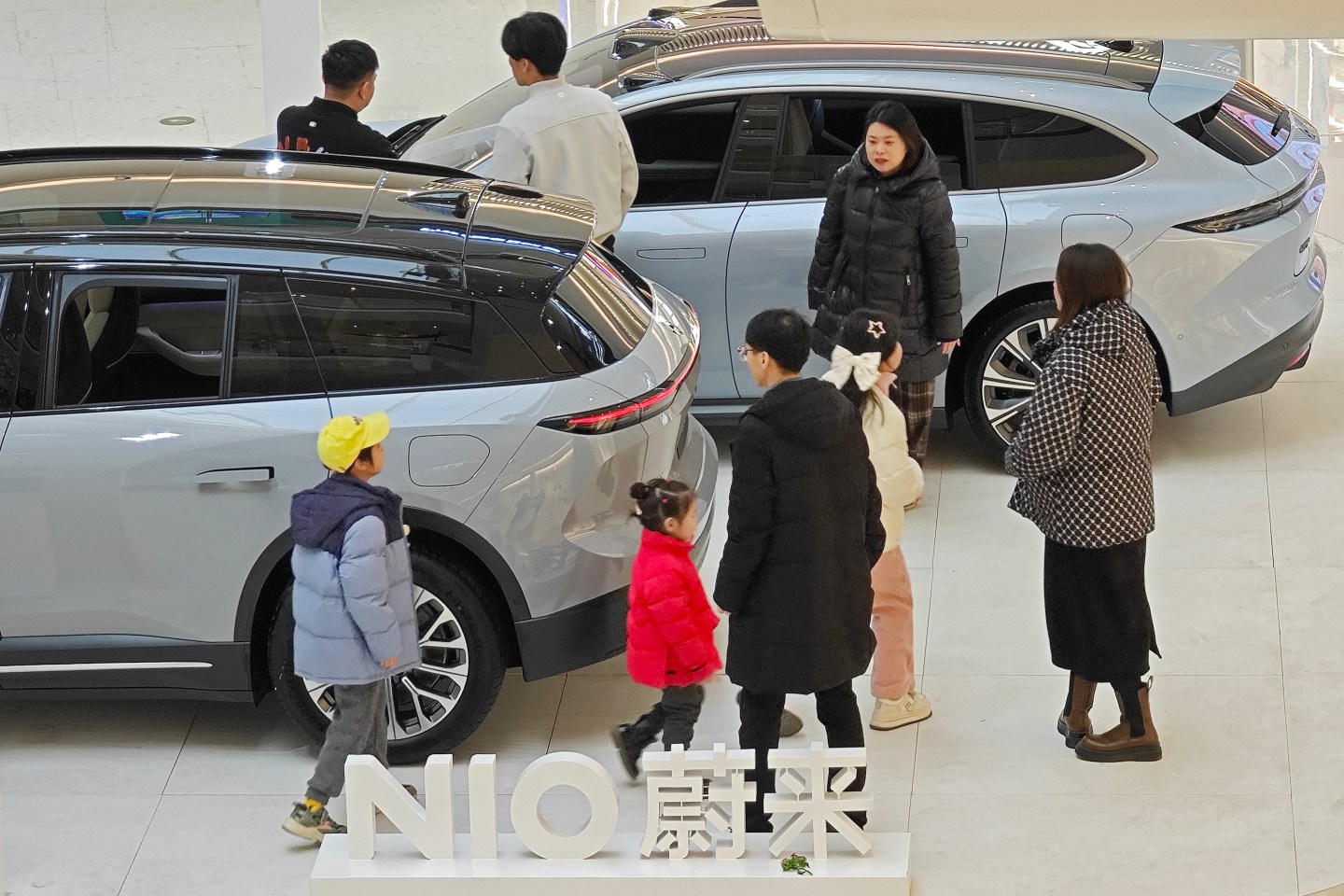 Customers standing around a NIO electric car.