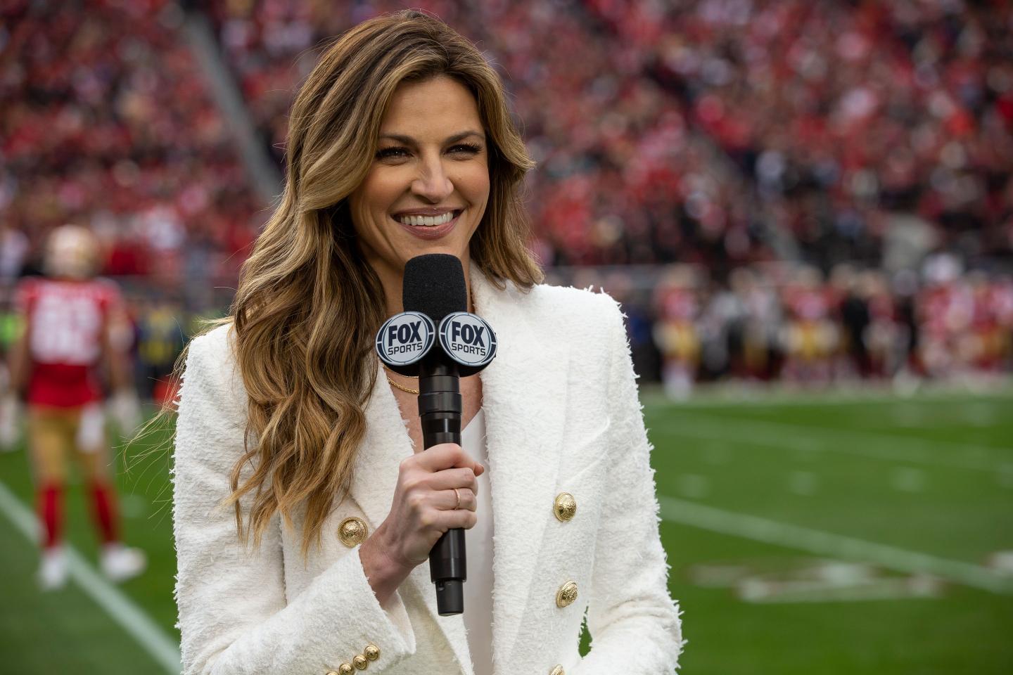 female television reporter standing on a football field