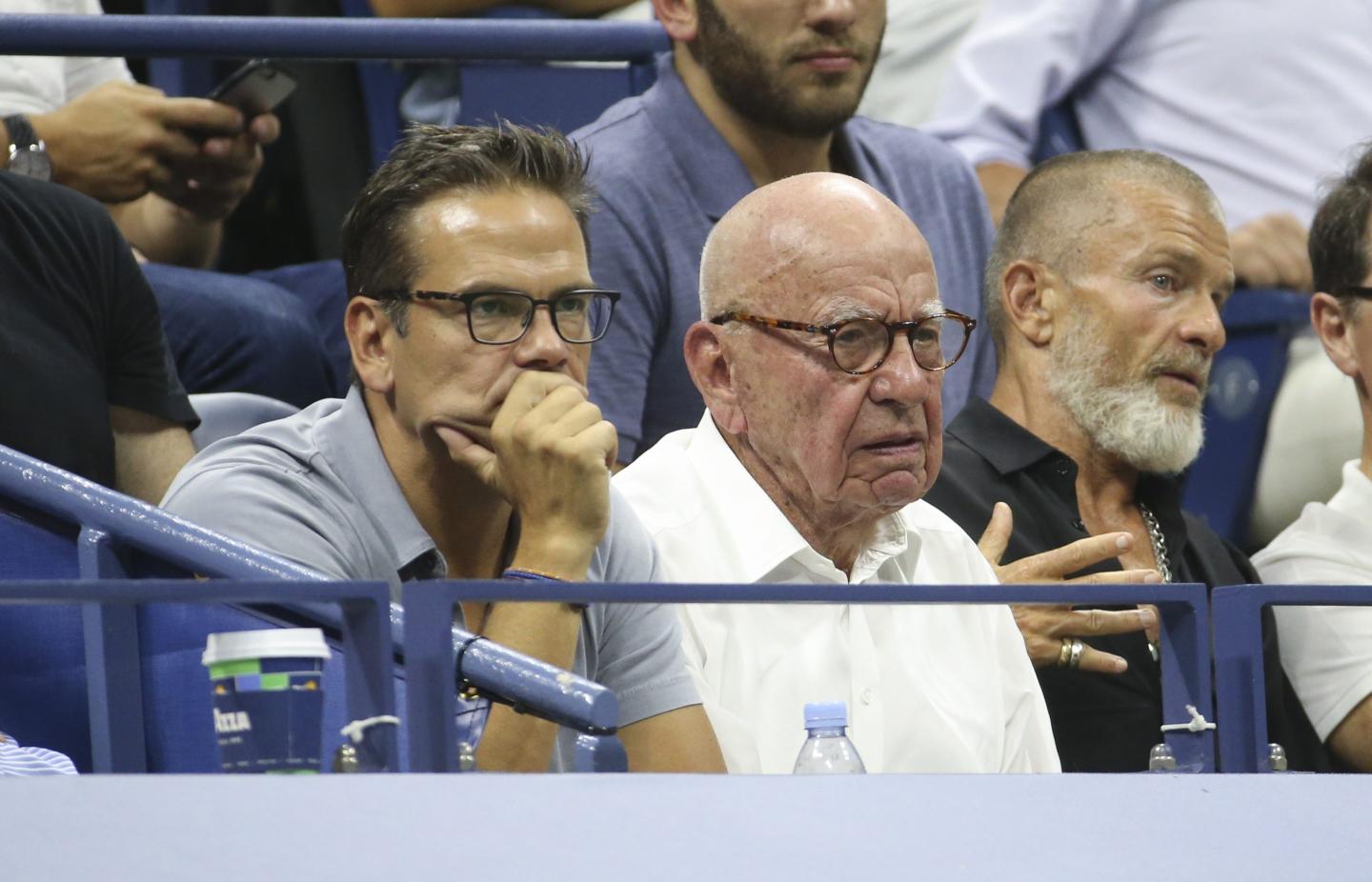 two men sitting on the stands of a tennis match