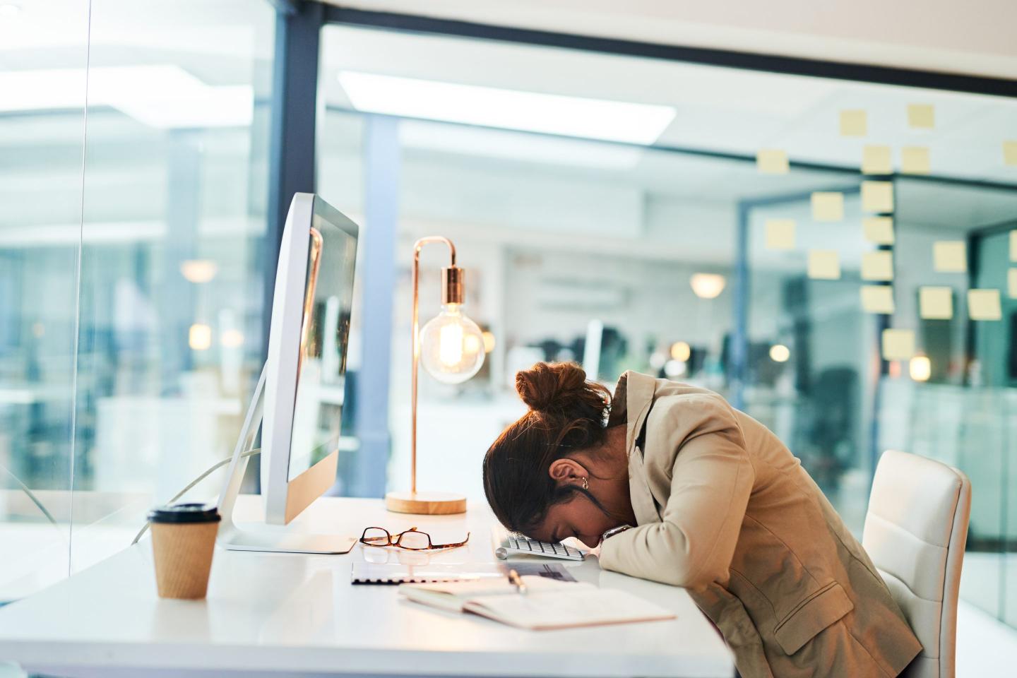 Shot of a young businesswoman sleeping at her desk in an office