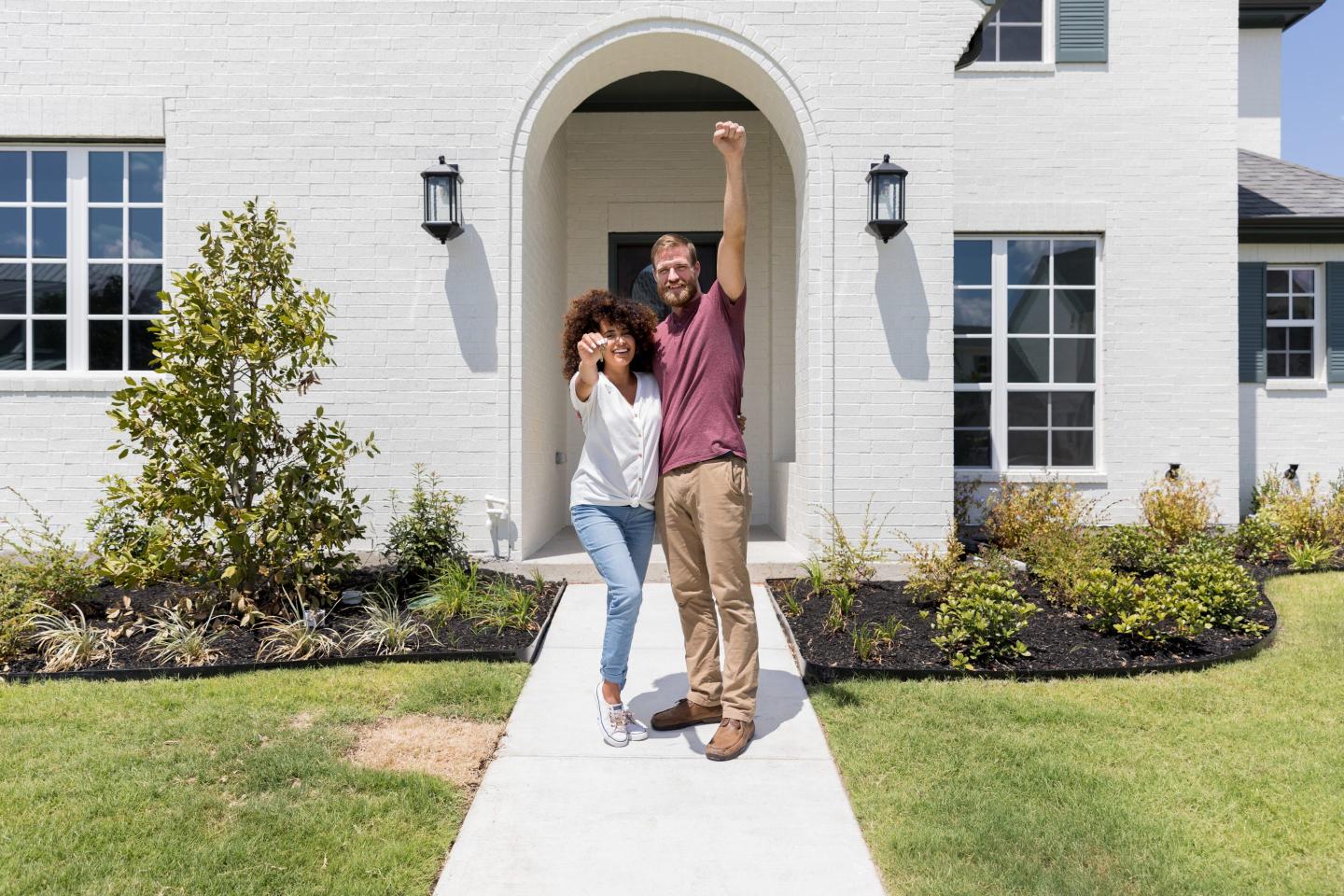 Couple standing outside of house they just bought