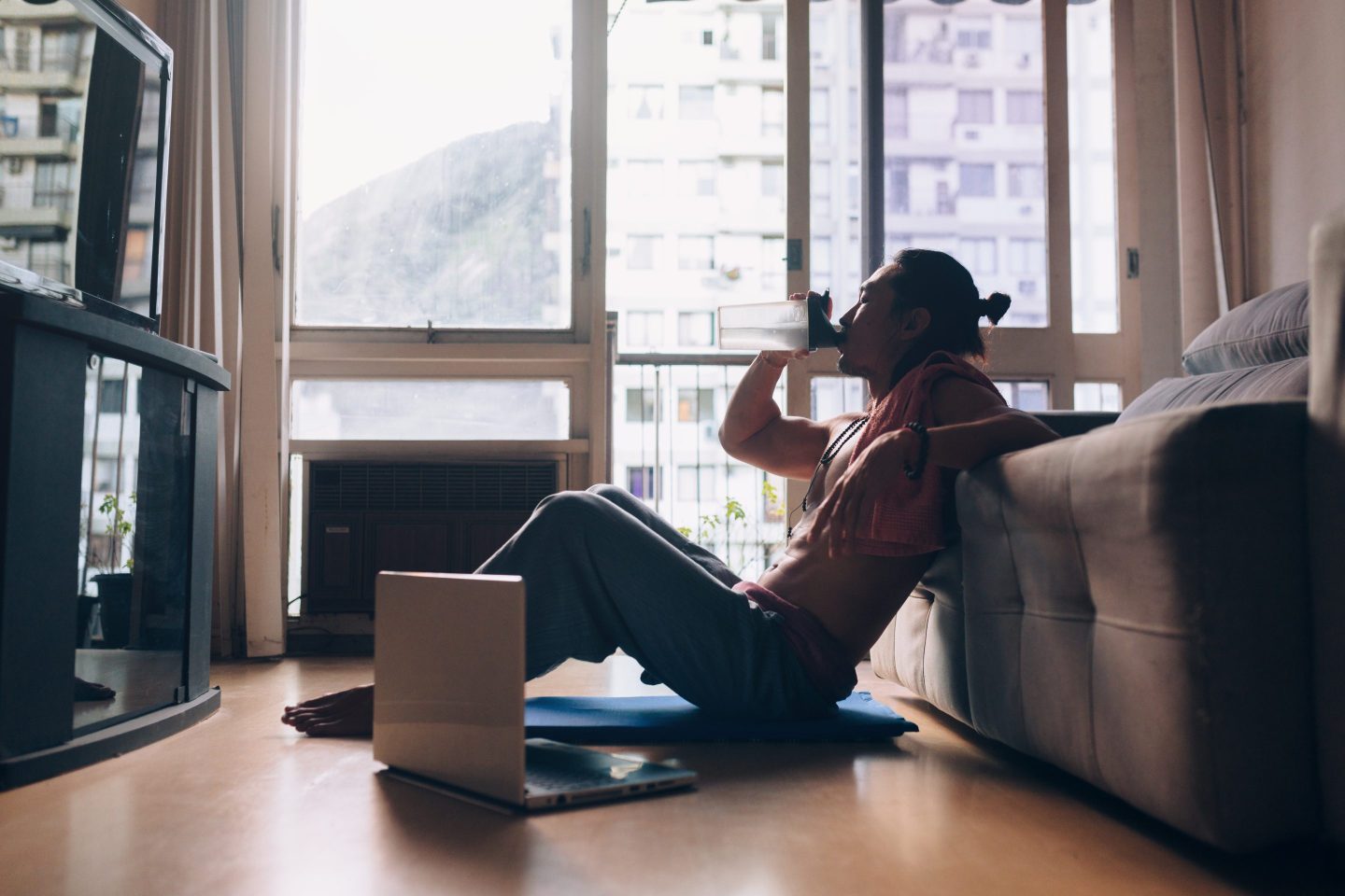 Man sits on floor drinking water