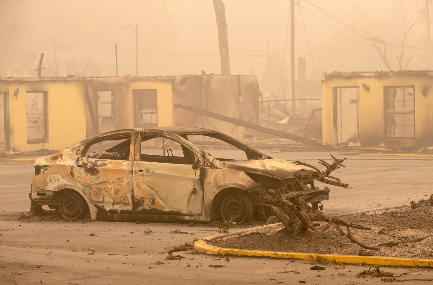 The carcass of a burned car is seen by the Oak Park Motel destroyed by the flames of the Beachie Creek Fire in Gates, east of Salem, Oregon