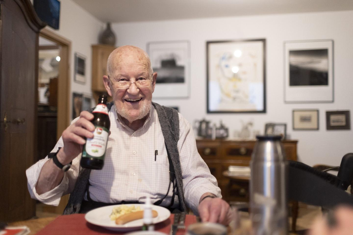 Happy old man drinking a beer