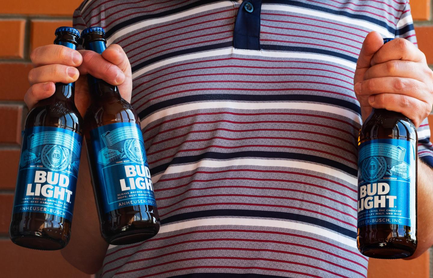 person holding bud light bottles