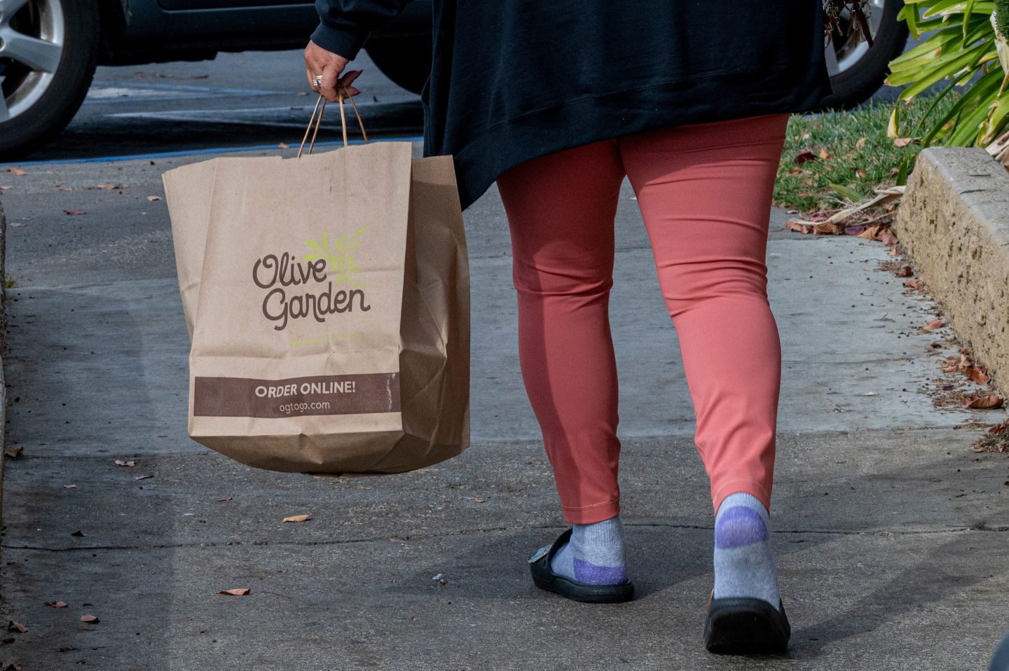 Customer carrying Olive Garden to-go bag