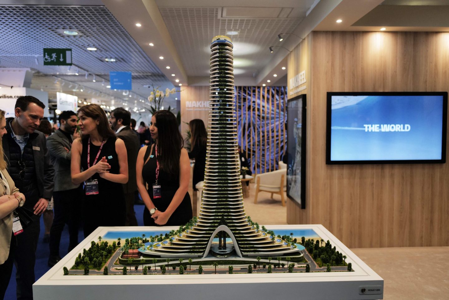 Visitors look at the model of "Tower Dubai" project during the MIPIM international real estate event for professionals at the Palais des Festivals in Cannes, southeastern France, on March 14, 2023.