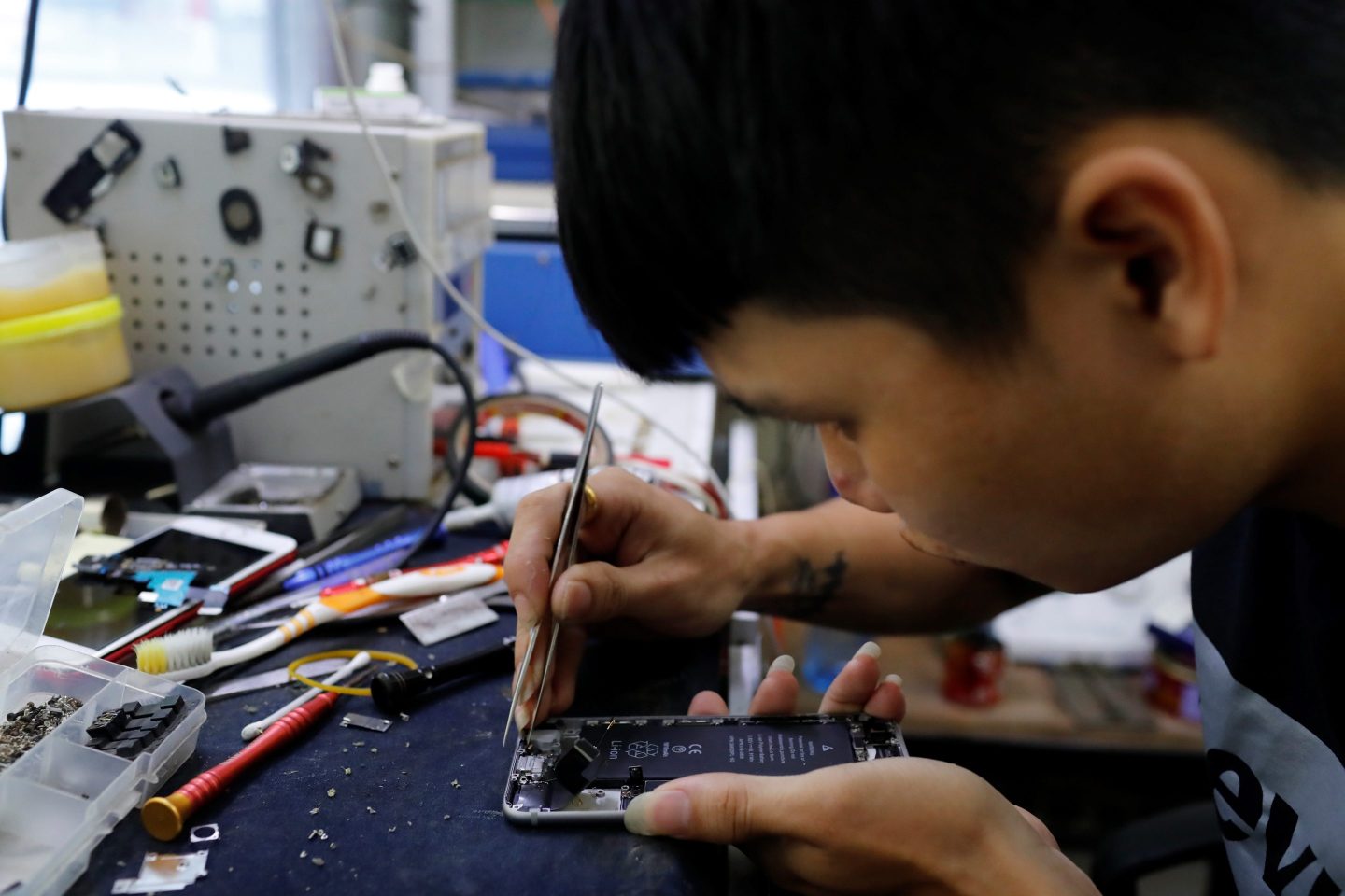 A man repairs a broken phone display in Hoi An, Vietnam.