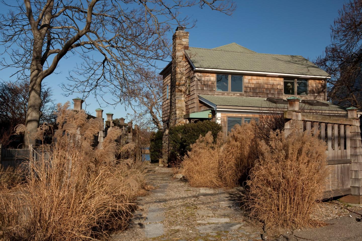 An old house, different from the one on the market, on the water of the Long Island Sound in the winter.