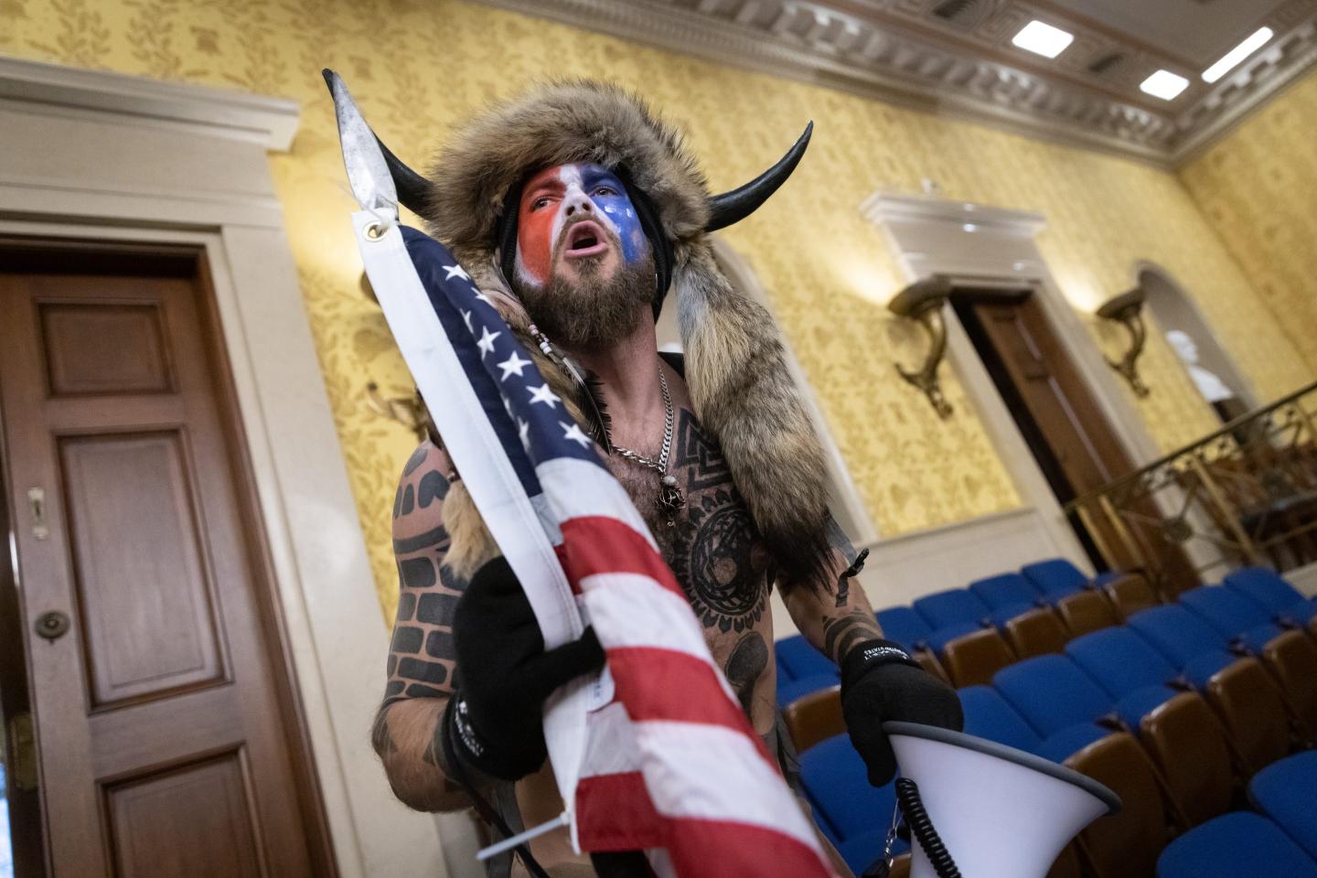 Jacob Chansley, also known as the "QAnon Shaman," screams "Freedom" inside the U.S. Senate chamber after the U.S. Capitol was breached by a mob during a joint session of Congress