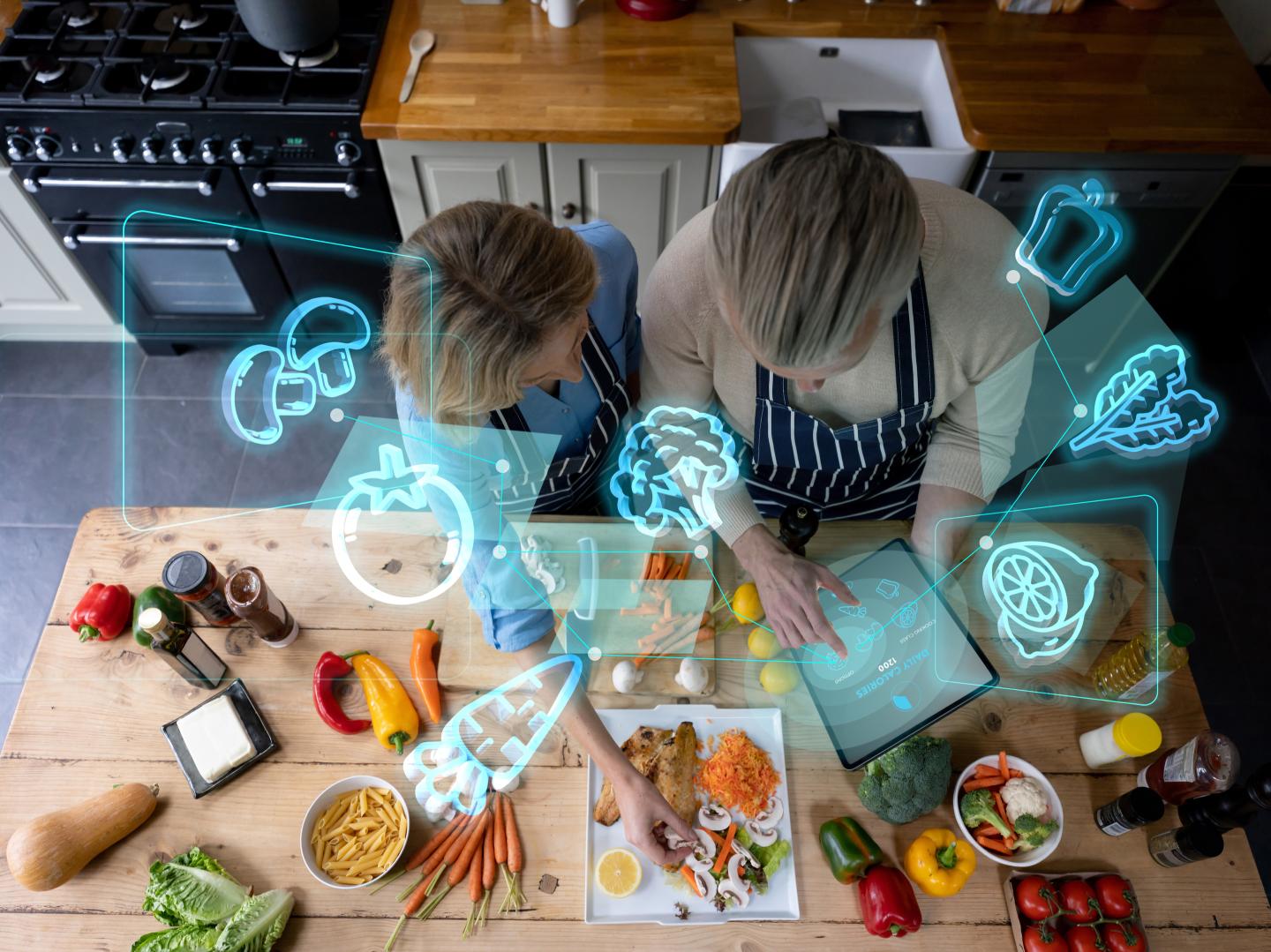 A couple cooking at home using a laptop for the recipe
