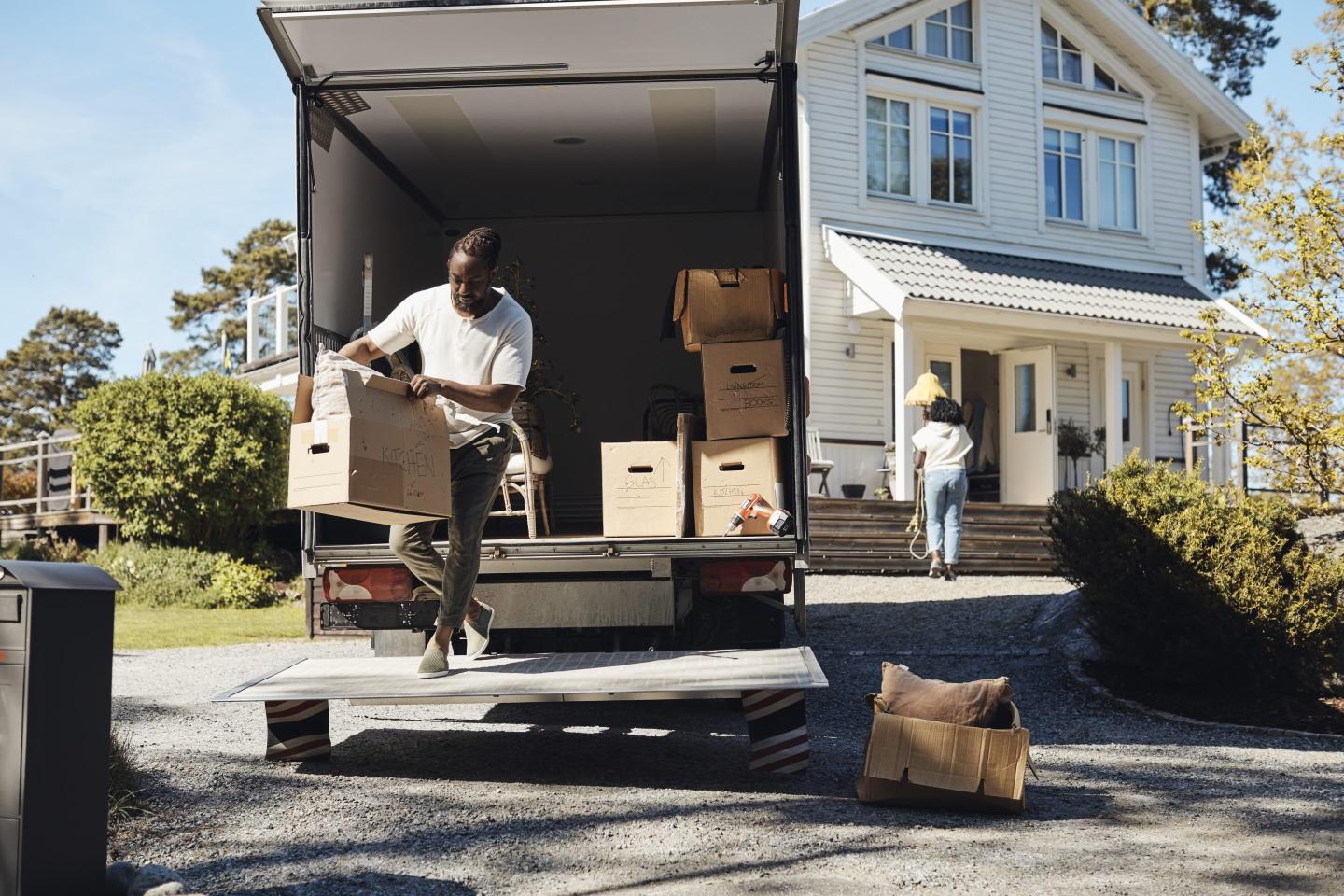 Photo of man unloading cardboard box from van