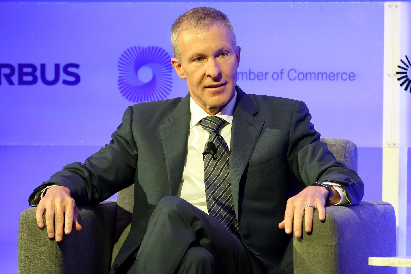 United CEO Scott Kirby is wearing a dark suit and is sitting on a chair onstage.