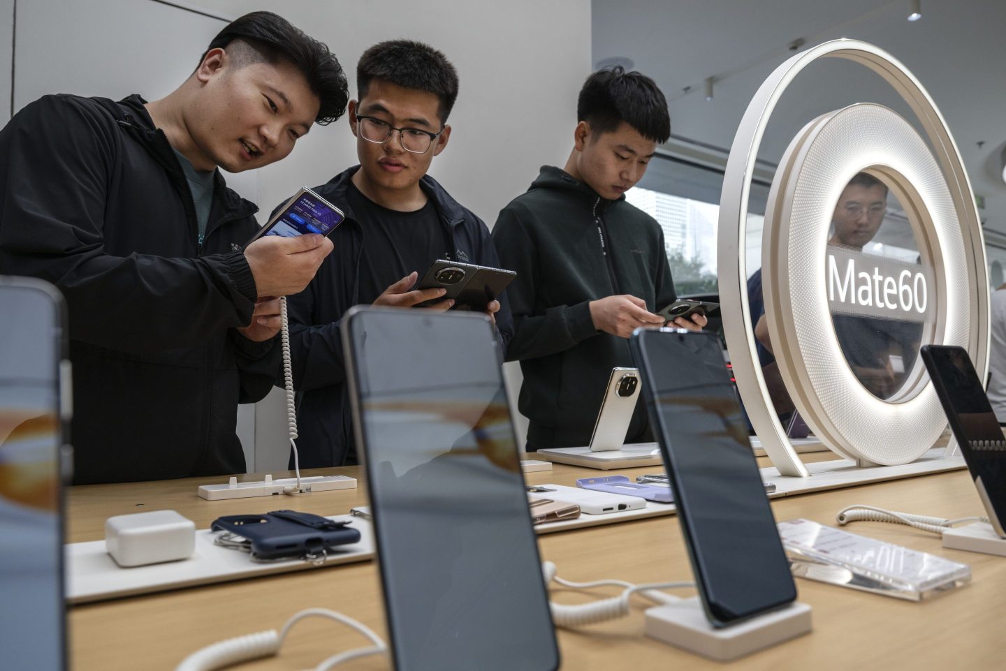 People look at newly launched smartphones at a Huawei flagship store after the company unveiled new products on Sept. 25, 2023 in Beijing. China's Huawei recently unveiled its new line of smartphones, including the Mate 60, which features a Chinese-made chip.